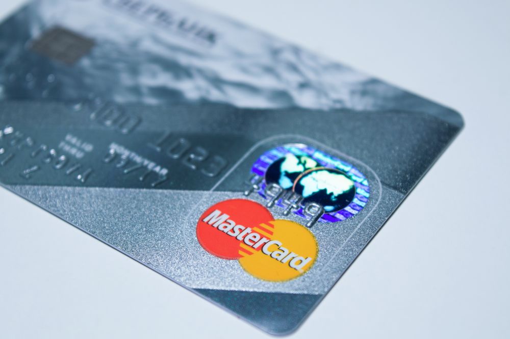 A metal credit card on a pale surface